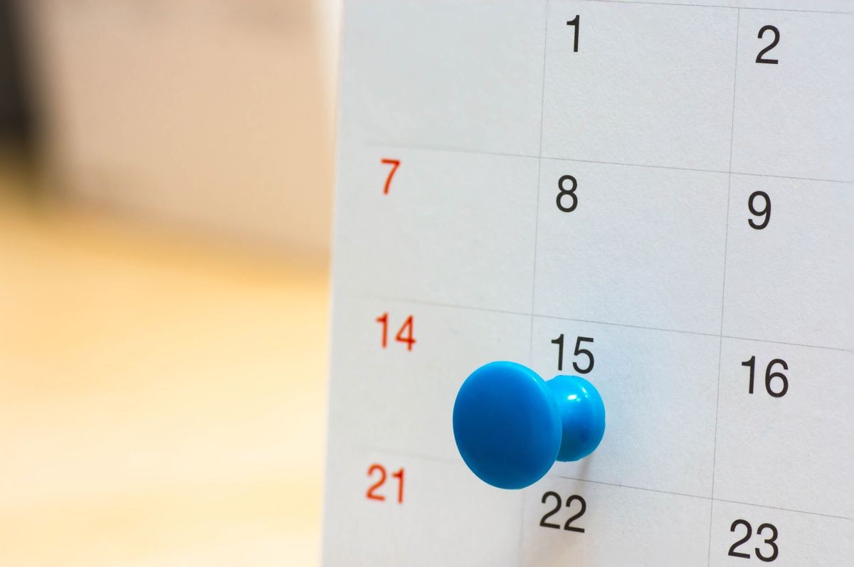 blue color flag pin thumbtack a date on calendar or planner.
Tax Day falls on April 15th 2024 each year. planning for business meeting travel or plan job. 
(selective focus)